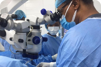 Ophthalmologists looking though a microscope and performing surgery